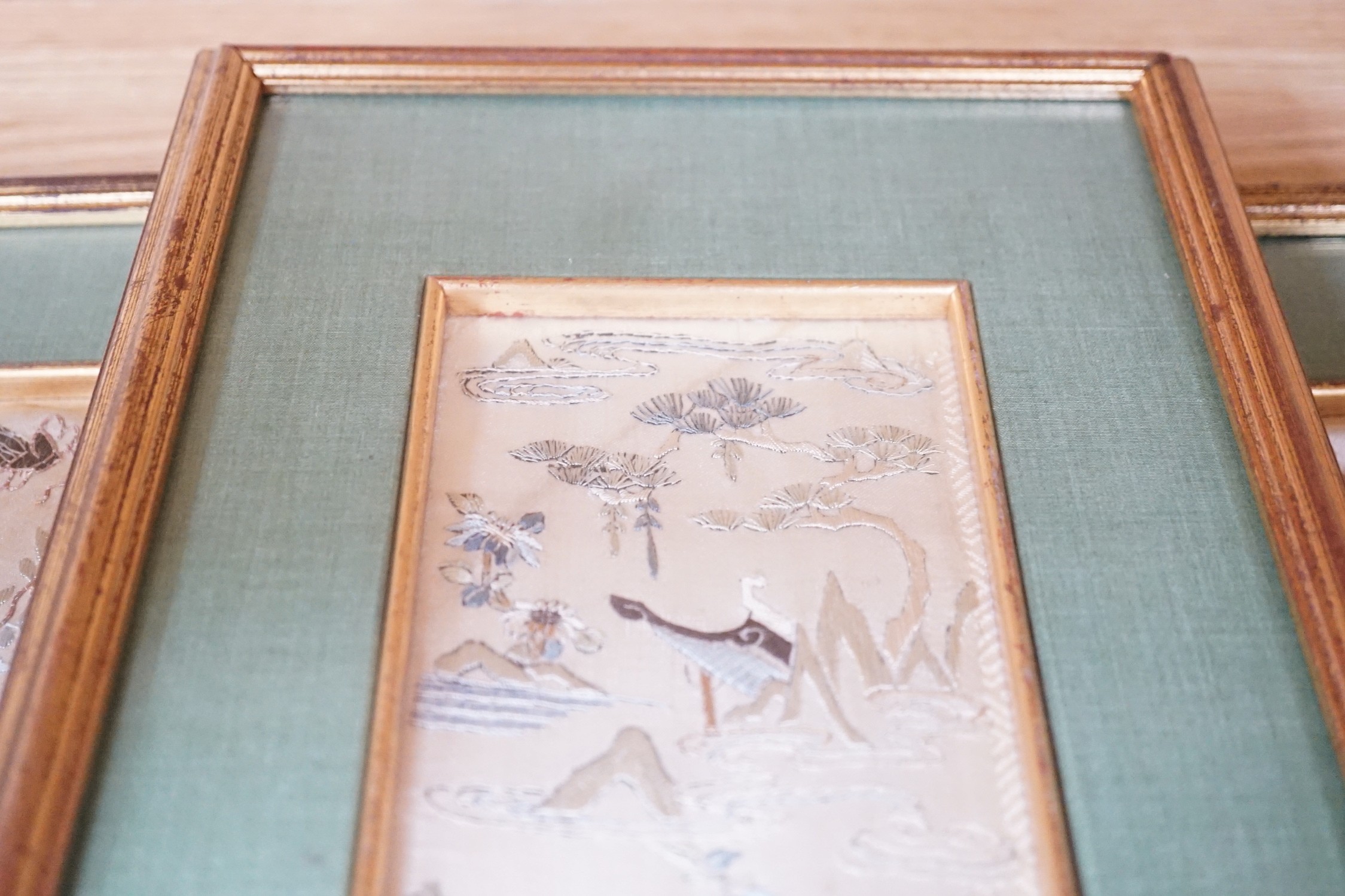 Three pairs of gilt framed, 19th century, silk embroidered, sleeve bands (for Chinese robes), 49cms long x 9cms wide (not including mount or frame)